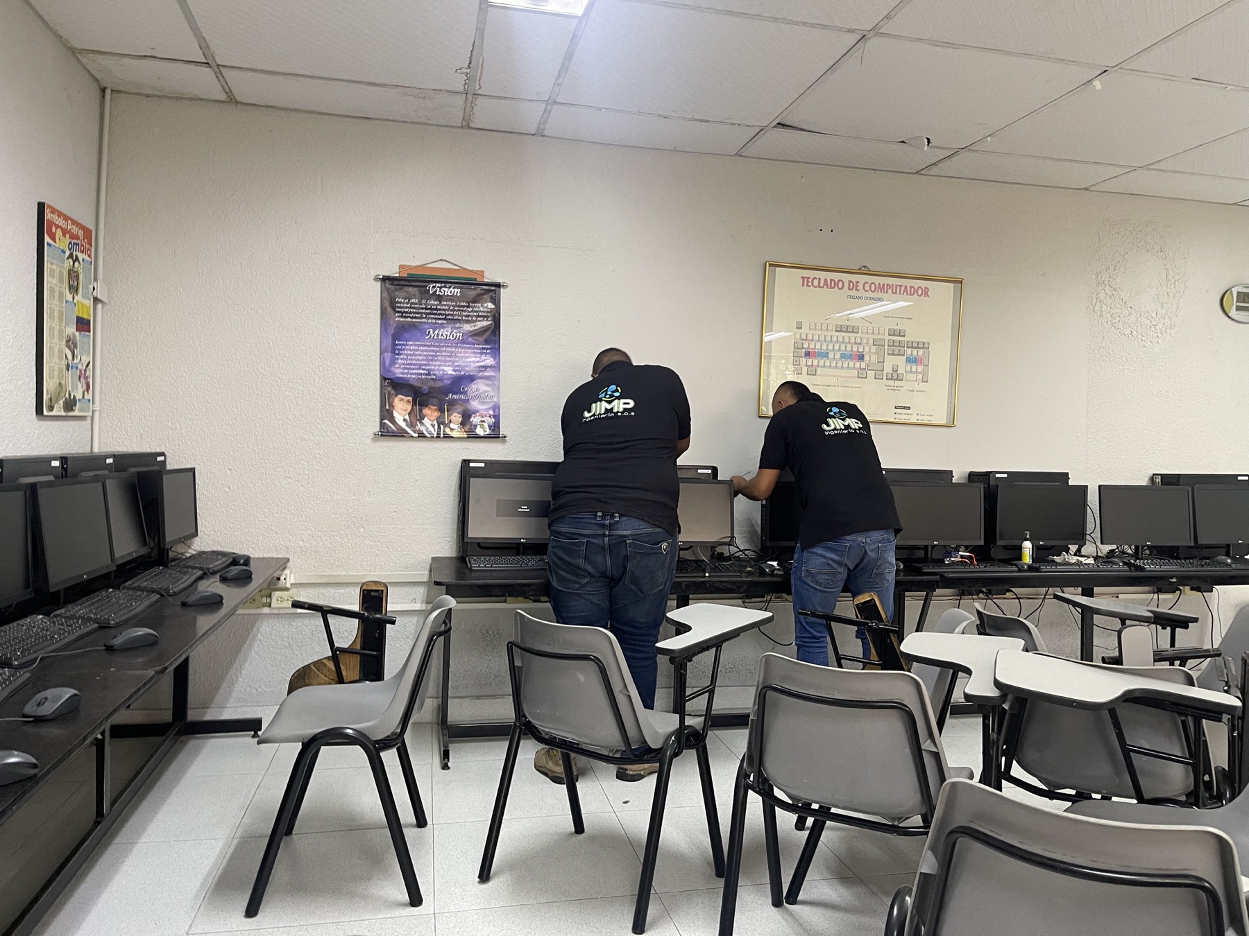 Dos técnicos de JIMP trabajando en la sala de informática del Colegio Américas Unidas