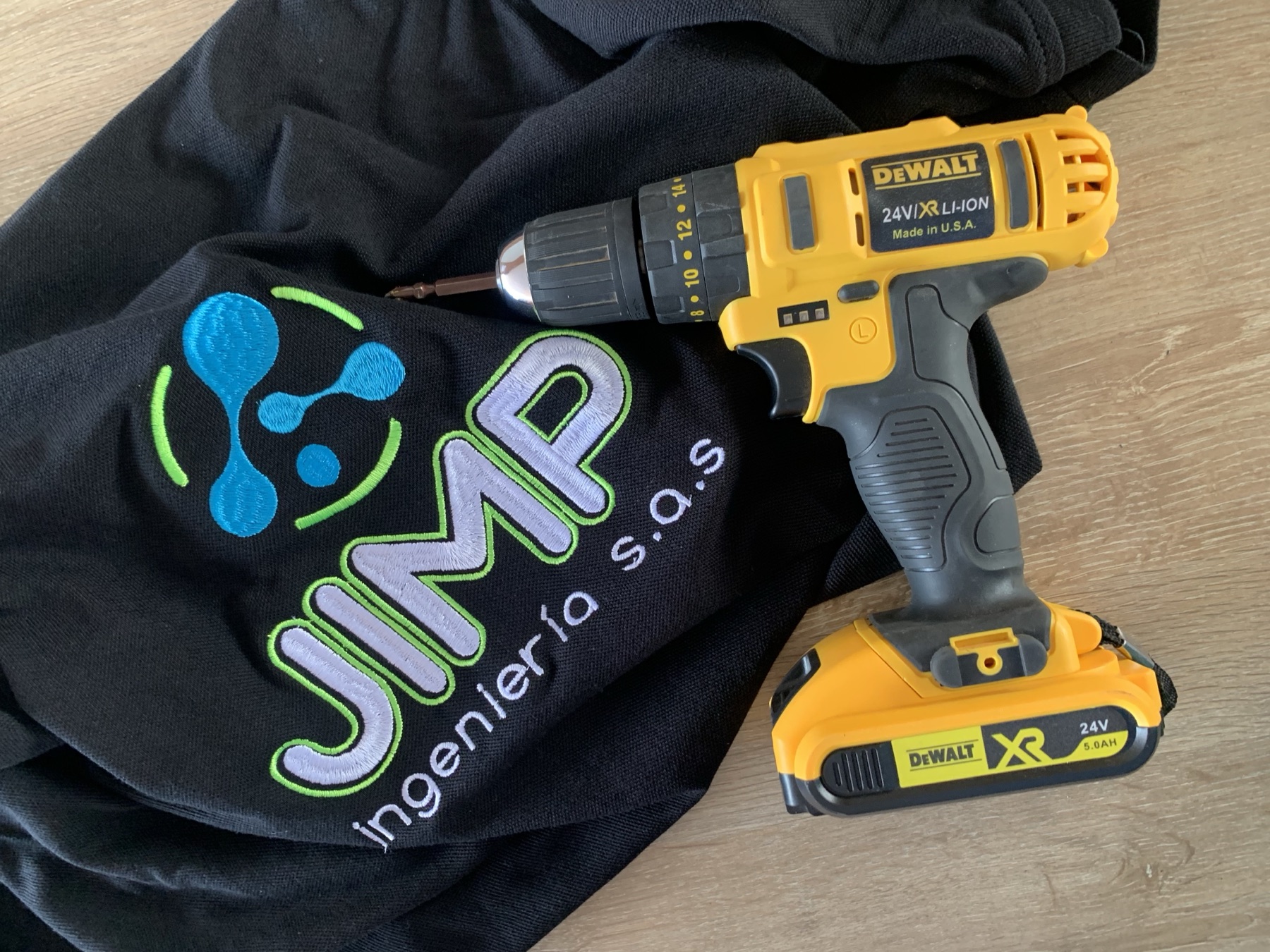 Uniforme bordado de JIMP Ingeniería junto a una herramienta de trabajo